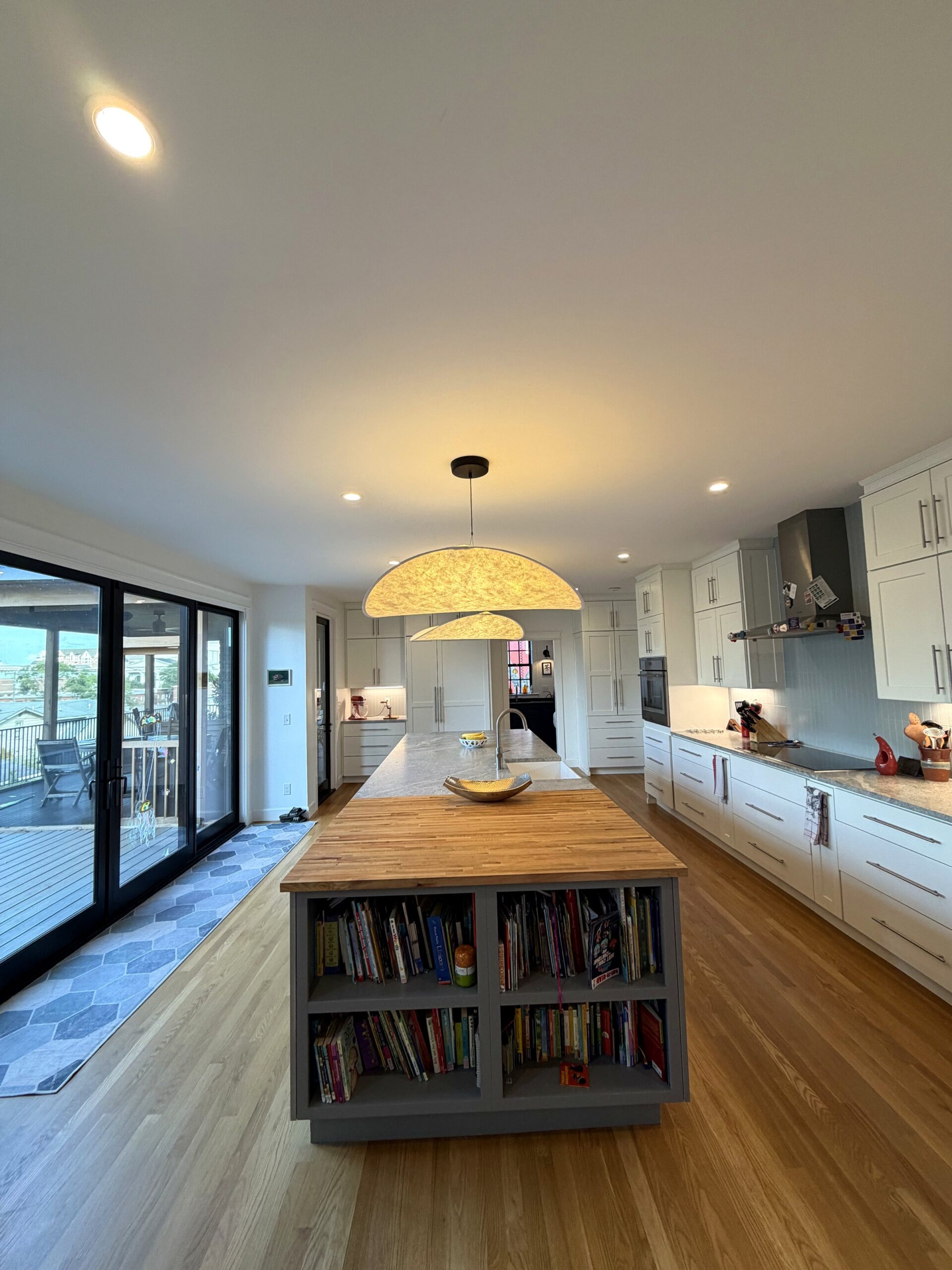 Kitchen with large island, bookcase shelving, and wood countertop