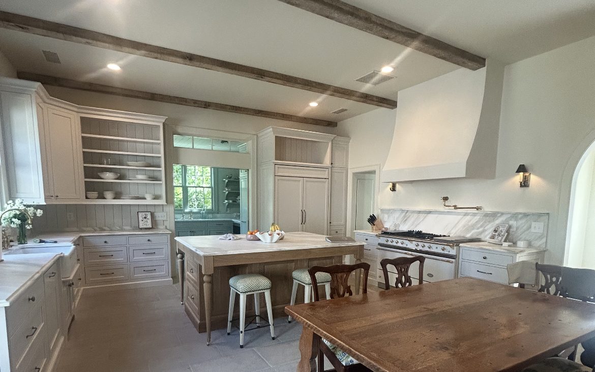 Renovated kitchen with island, exposed beams, and custom cabinetry